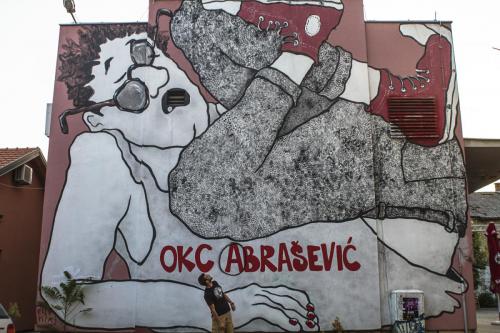 Amar Maksumić devant le graffiti à l’entrée d’Abrašević